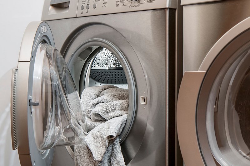Person naturally cleaning a front loader washing machine door and seal